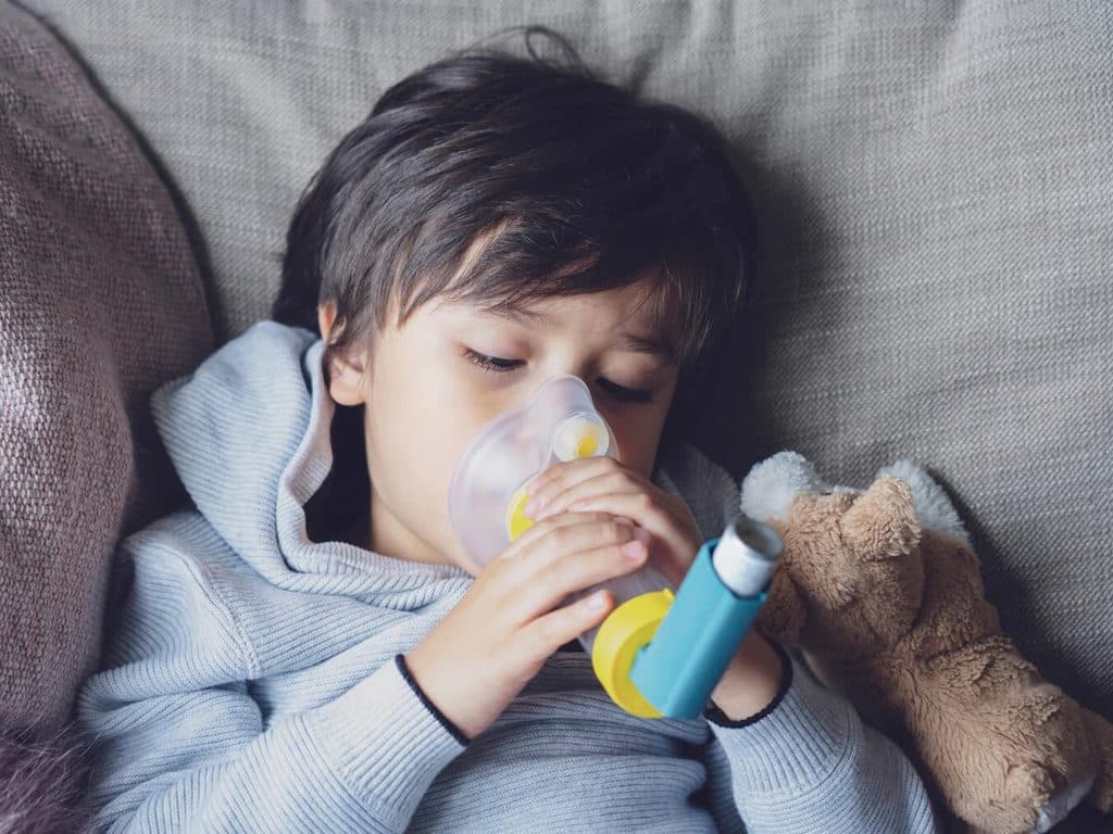Niño con tratamiento de asma mediante inhalador en Ourense